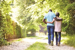 Older couple walking on wooded path